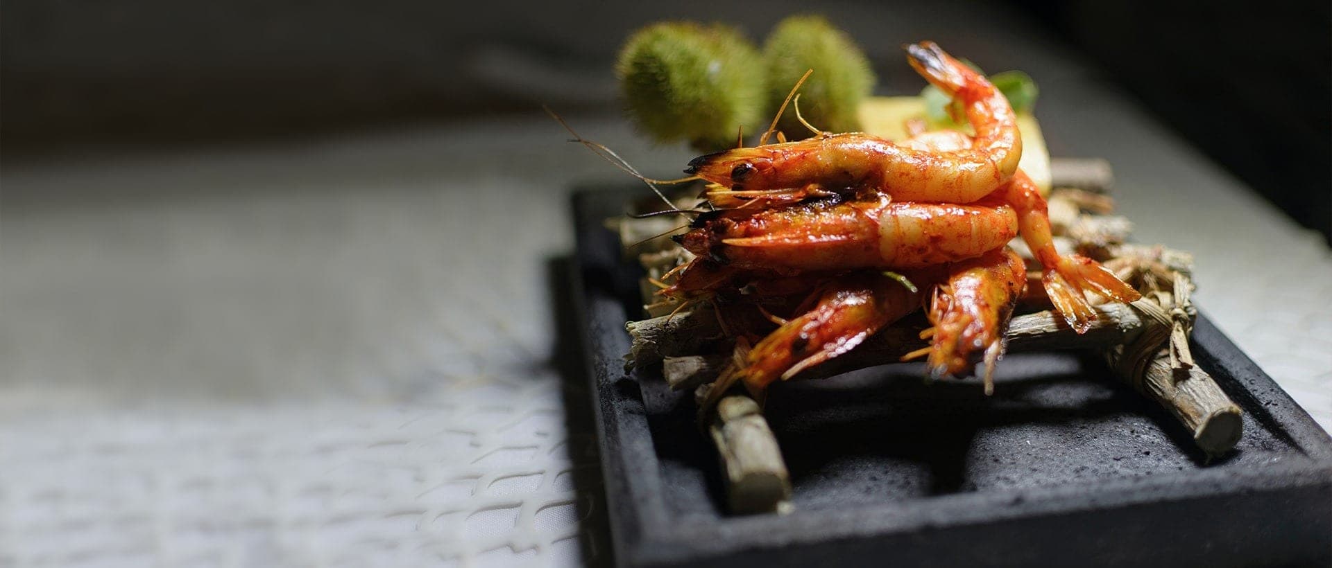 Gambas rouges grillées à la braise servies sur ardoise chez Basilico