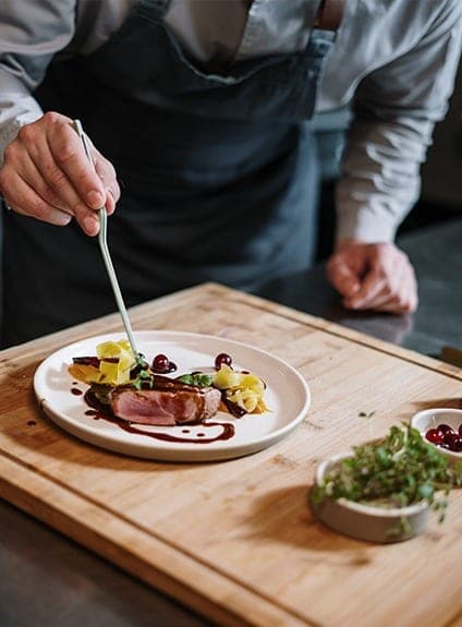 Dressage d’une assiette sur la planche, au poste chaud de Basilico